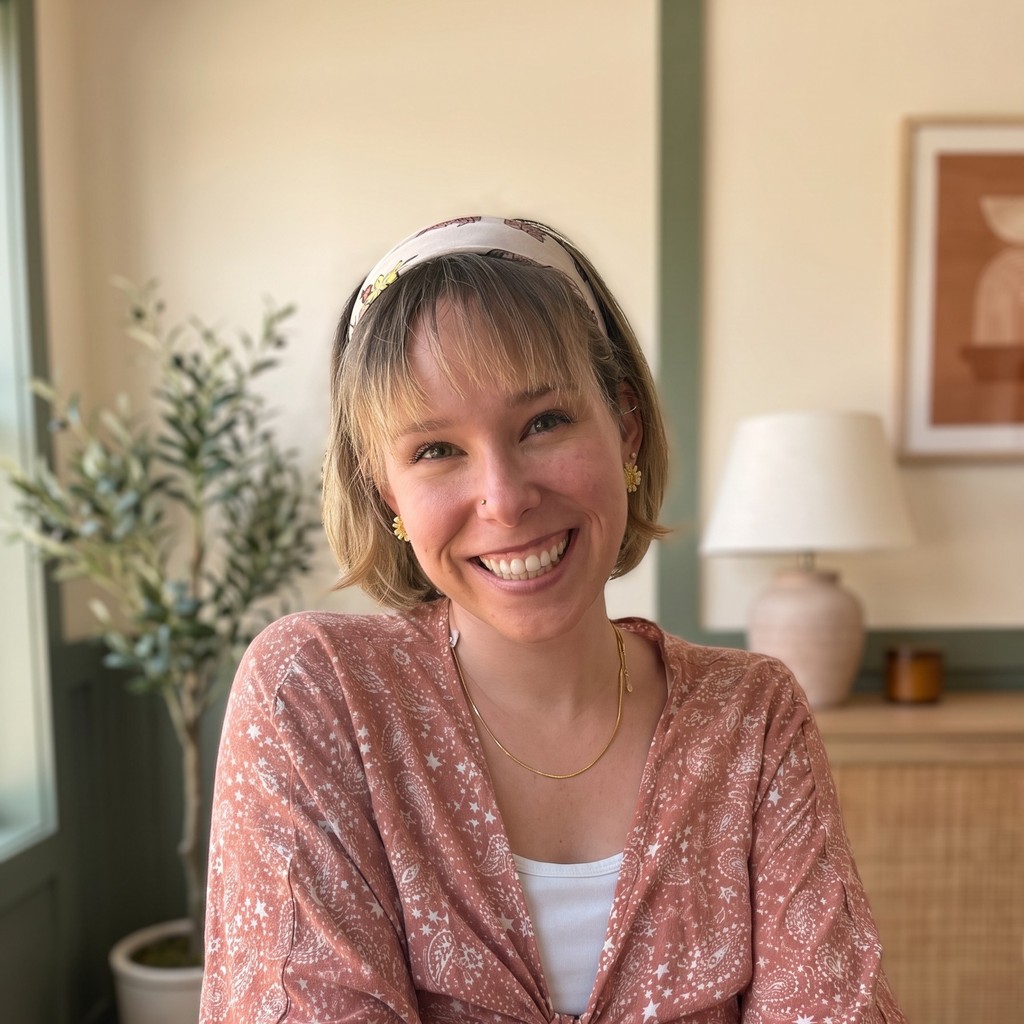 Hannah-Belle Hale, practicum student at Real Hope Counseling, smiling in a cream office in a dusty-rose blouse.