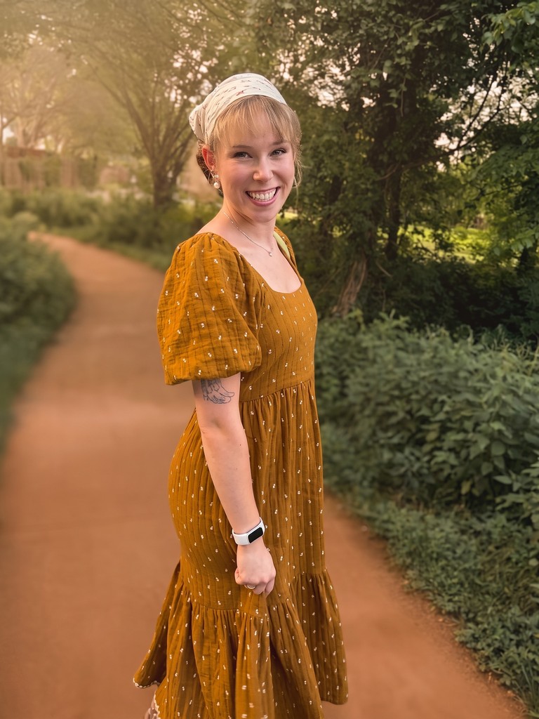 Hannah-Belle Hale, practicum student at Real Hope Counseling, smiling outdoors in a mustard dress.